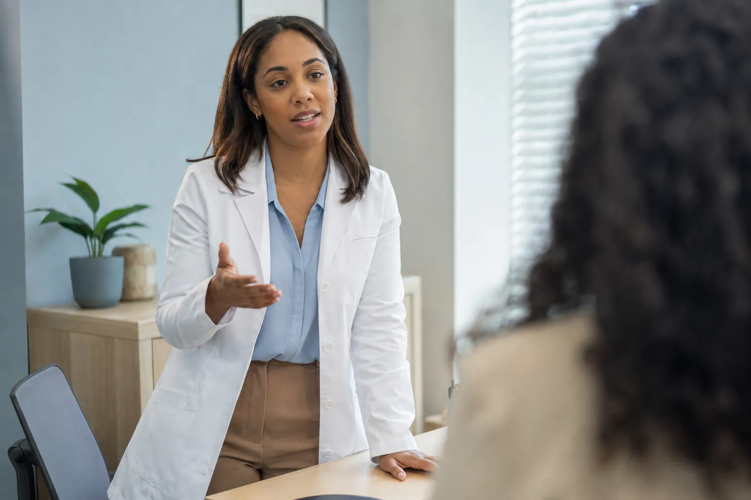 Médica conversando con una paciente en el consultorio